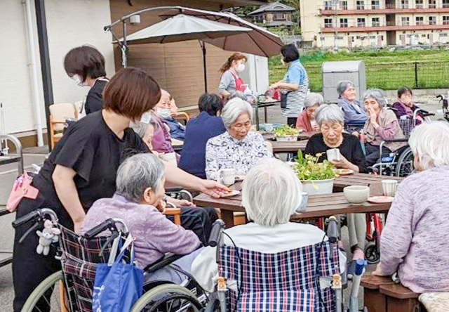 画像：職員と触れ合う入居者