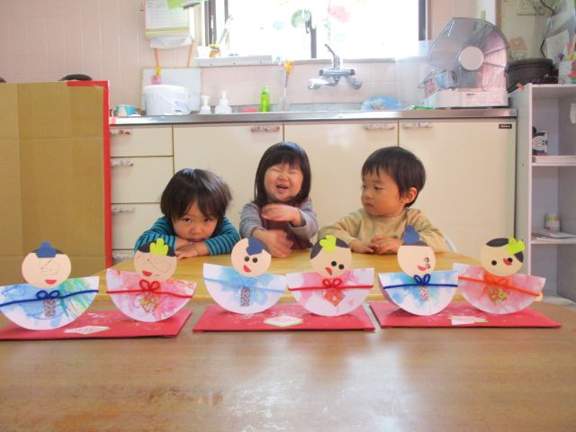 画像：紙製の雛人形を並べる園児