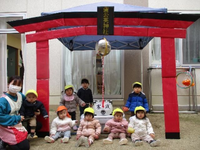 画像：手作り神社の前でポーズを取る園児