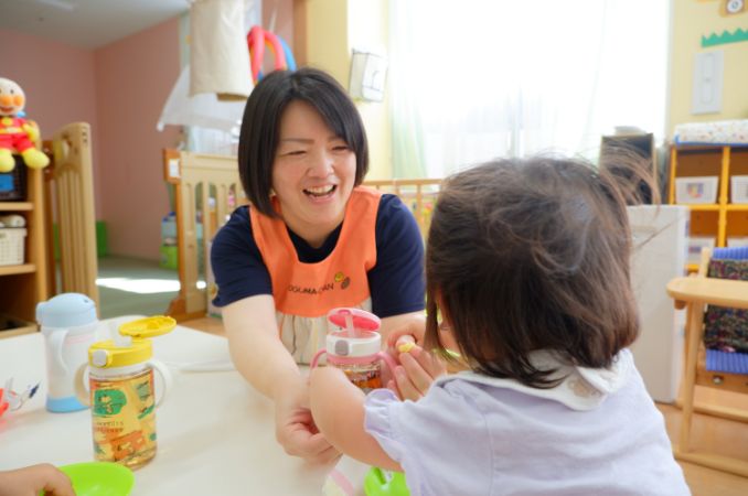 画像：園児と遊ぶ職員